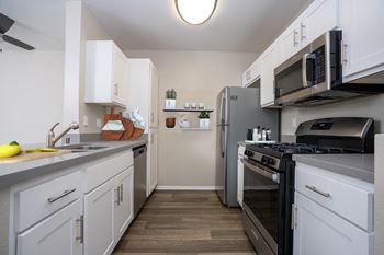 A kitchen with white cabinets and black appliances.